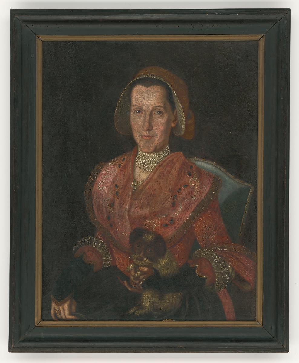 Porträt einer sitzenden Frau mit Rokokohaube und einem Hund im Arm