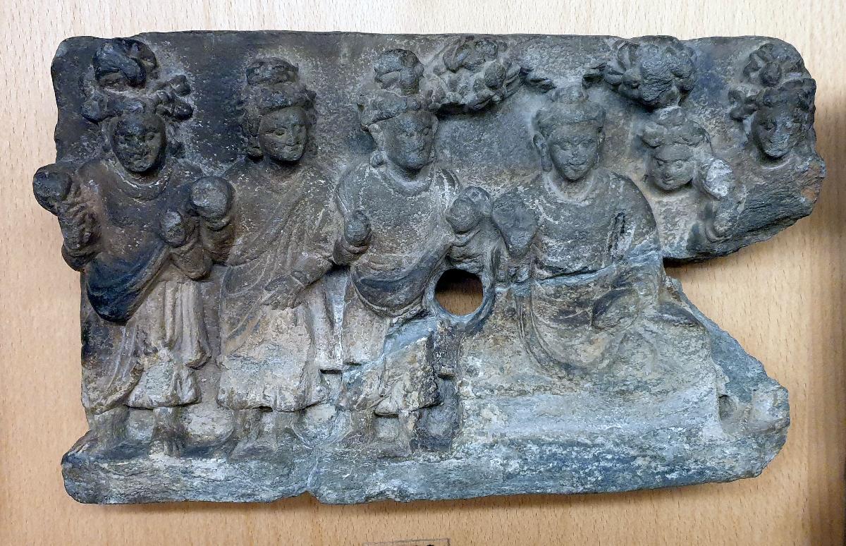 Sitzender Buddha in Schutzgeste (abhaya-mudra) unter blühendem Baum inmitten stehender männlicher Verehrer (Fragment)