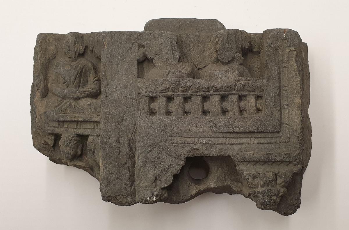 Teil einer vertikalen Stele (Fragment): Zwei weibliche Büsten auf Balkonbrüstung (rechts); meditierende Buddhas in übereinandergestaffelten Bildfeldern (links)