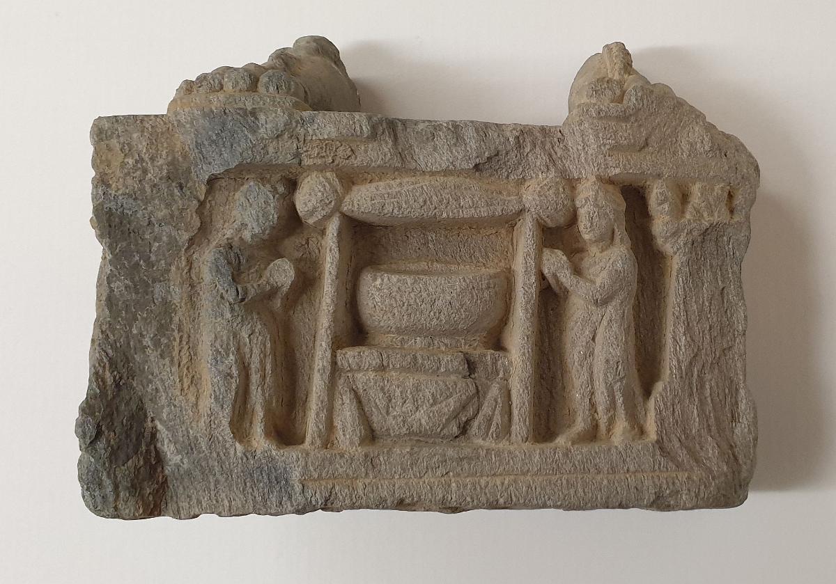 Füße eines stehenden Bodhisattva. Sockelrelief: Verehrung einer Bettelschale (patra)