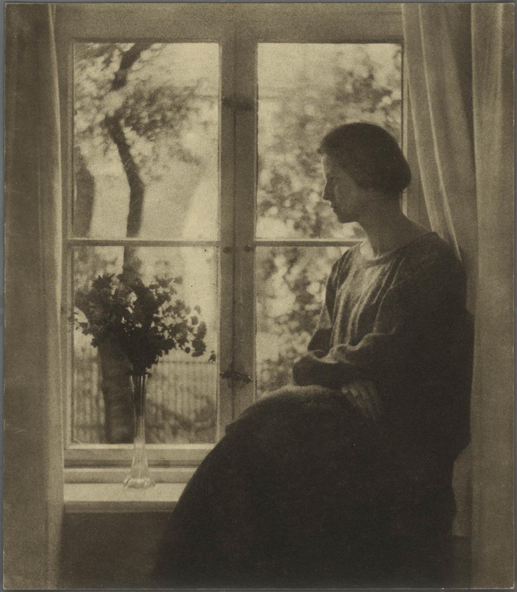 Frau am Fenster sitzend