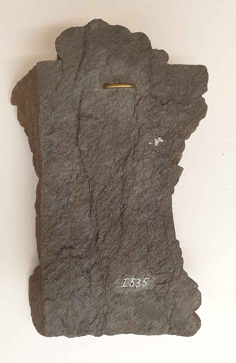 Fuß eines stehenden Buddha (Fragment). Sockelrelief: zwei Mönche unter Akanthusblattfries