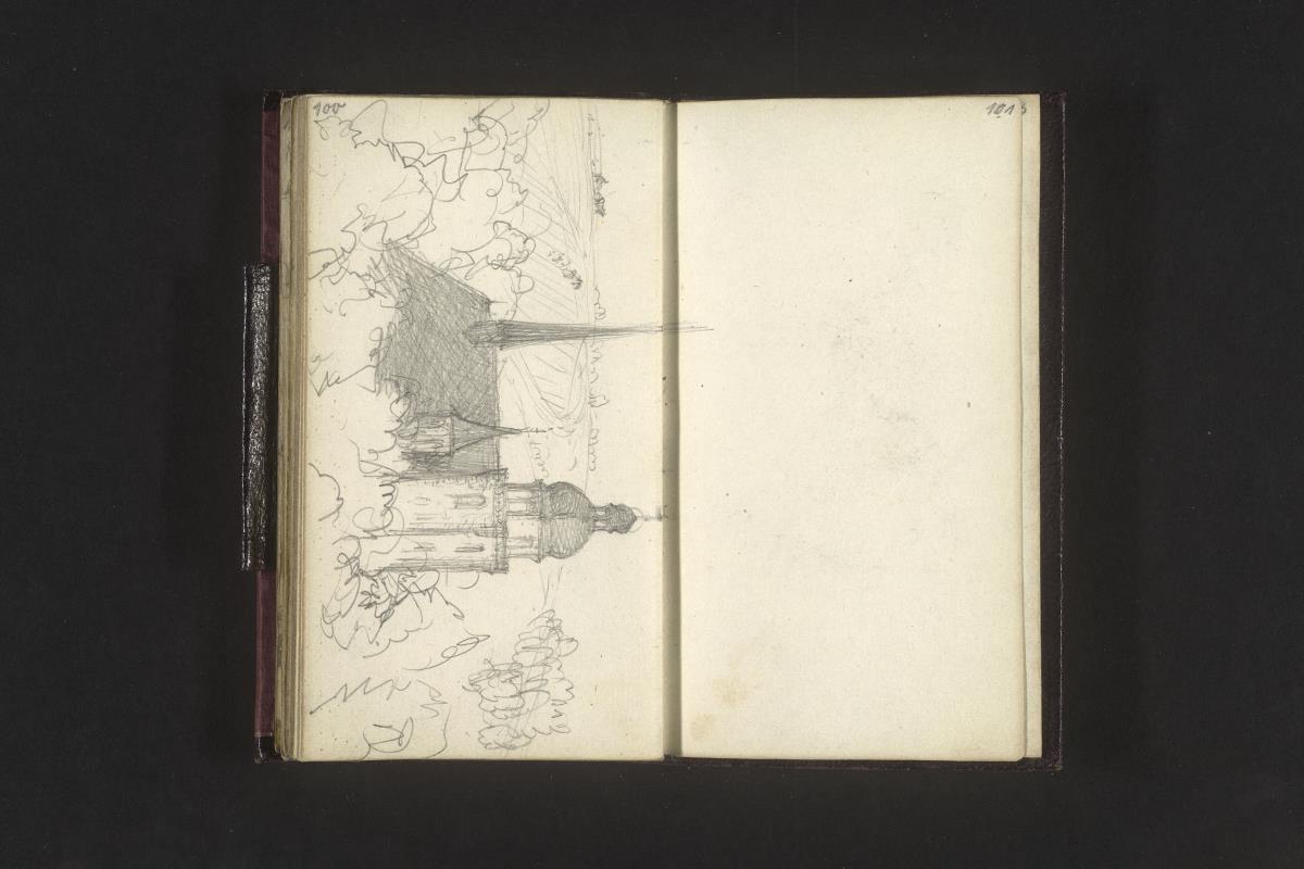 Dach und Turm einer von Bäumen umstandenen Kirche in hügeliger Landschaft