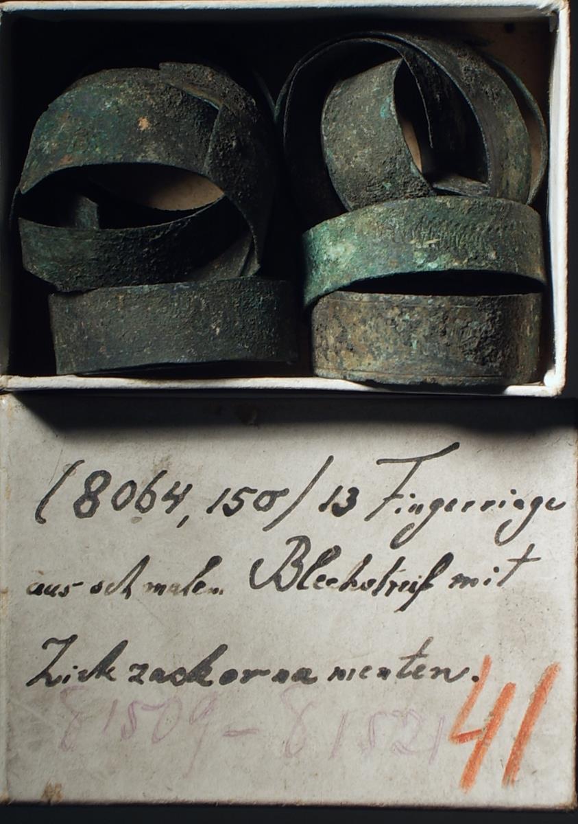 13 Fingerringe aus dünnem, schmalem Blechstreifen zusammengebogen und mit Zickzackornamenten im sog. Tremolierstich verziert