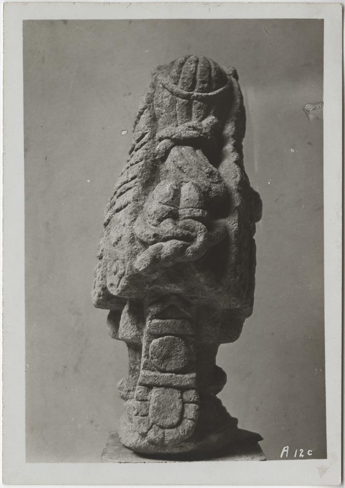 "Ansicht einer sehr eigenartigen Steinfigur (hellgrauer Tezontli). "... Kopf trägt reichen Blumenschmuck, rechte Hand Blumenstrauß, linke Hand Blume (Calla). Ohrschmuck des Macuilxochitl. Glockengürtel, Schambinde, Sandalen, Gesicht und Rumpf (Skelett!) des Gotes Xipe"