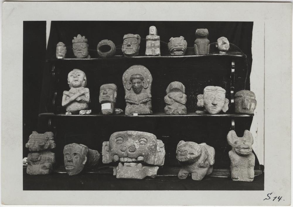 Steinköpfe und -figuren darunter Tlaloc-Gesichter aus der Slg. Sologuren