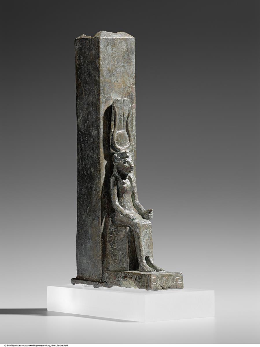 Tiersarg in Form eines Obelisken, davor eine Figur der thronenden Göttin Wadjet