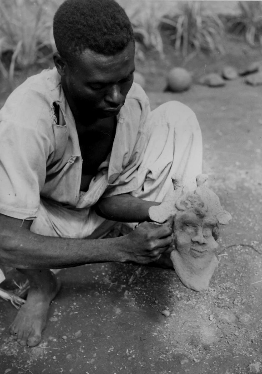 Foumban. Artisan modelant un masque en cire pour servir de modele au masque en cuivre