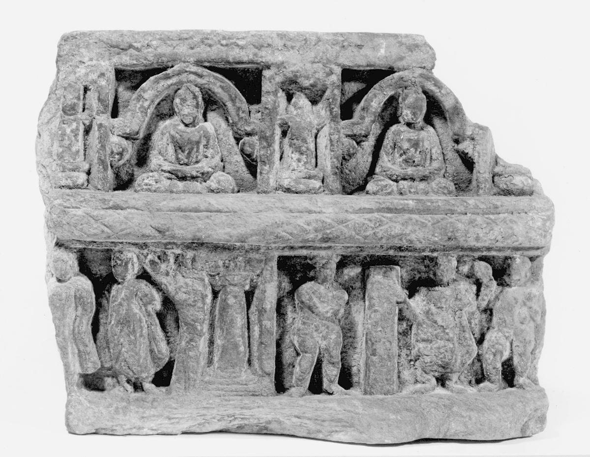 Mehrreihiger Fries (Fragment) mit zwei erzählenden Szenen (unten) und Schmuckfries (oben): Buddha entfernt den Fels auf dem Weg nach Kushinagara (unten rechts); unidentifizierte Szene (unten links); zwei meditierende Buddhas unter je einem Chaitya-Bogen (oben)