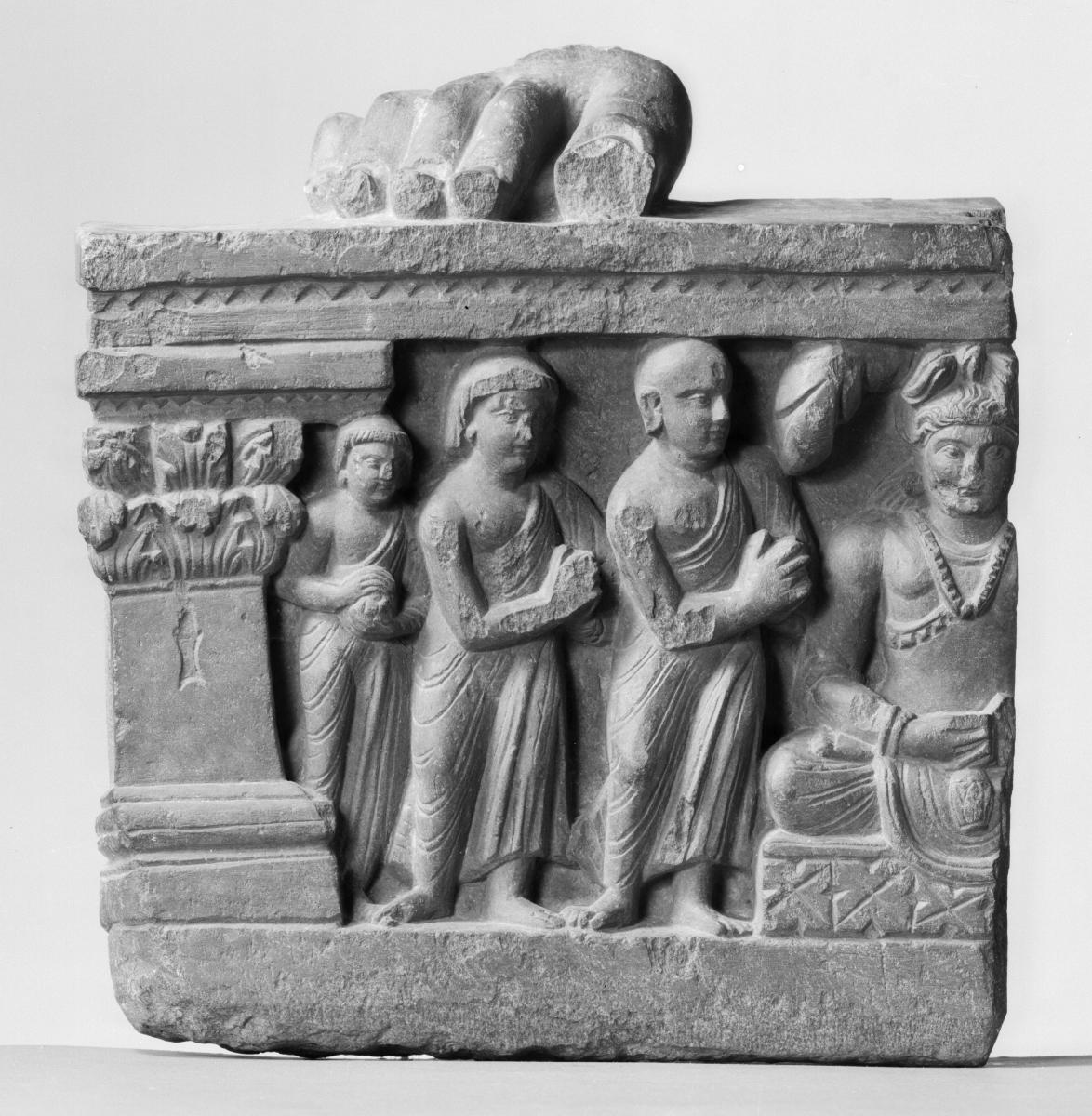 Fuß eines stehenden Buddha (?) (Fragment). Sockelrelief: Verehrungsszene mit zukünftigem Buddha Maitreya in Meditationssitz (Fragment)