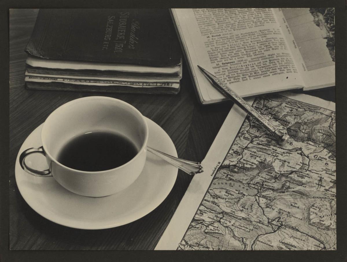 Stillleben mit Tasse, Stift, Karte und Reiseführer