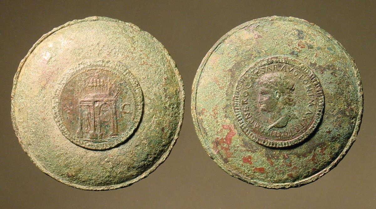 Römischer Dosenspiegel mit eingelassener, entzweigesägter Münze. A: Kopf des Nero mit Umschrift / B: Triumphbogen S. C.