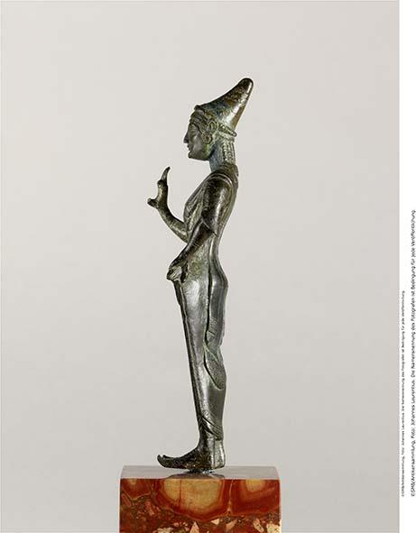 Etruskische Statuette einer Göttin in Gewand und spitzer Mütze, mit Inschrift auf dem Rücken