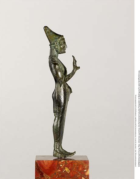 Etruskische Statuette einer Göttin in Gewand und spitzer Mütze, mit Inschrift auf dem Rücken