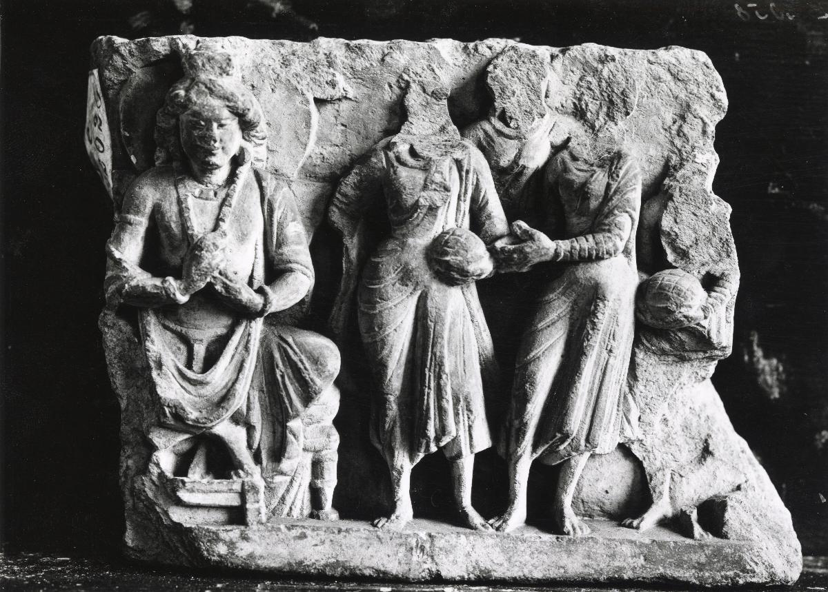Sockelrelief (Fragment): der zukünftige Buddha Maitreya auf Königsthron in Lehrgeste (dharmachakra-mudra, links); vier Adorant*innen mit Blumenkörben (?) (rechts)