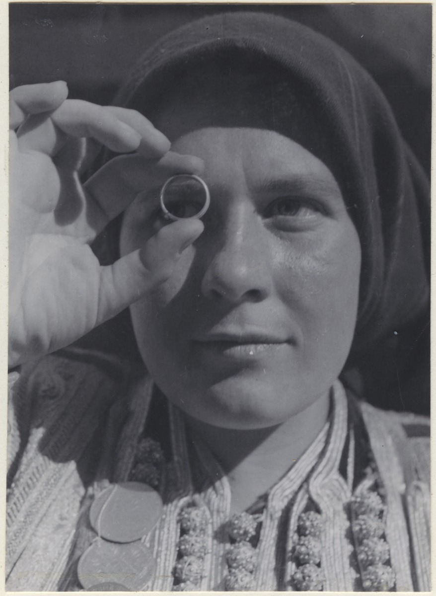 Die Braut schaut durch einen Ring nach dem Bräutigam
