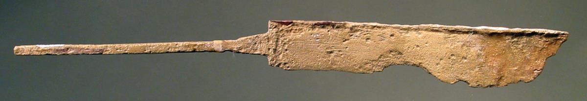 Längliches Messer mit feinem langen Griff, an dem auf den beiden Nebenseiten je fünf längliche kleine Blättchen aufgesetzt waren; einige dieser Blättchen sind jetzt abgesprungen