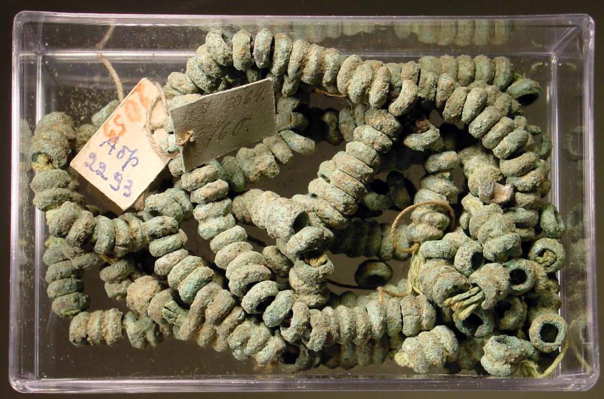 Große Kette aus kleinen runden Ringen, die zum Teil noch auf dem antiken Faden gereiht sind. Ein Teil modern aufgereiht