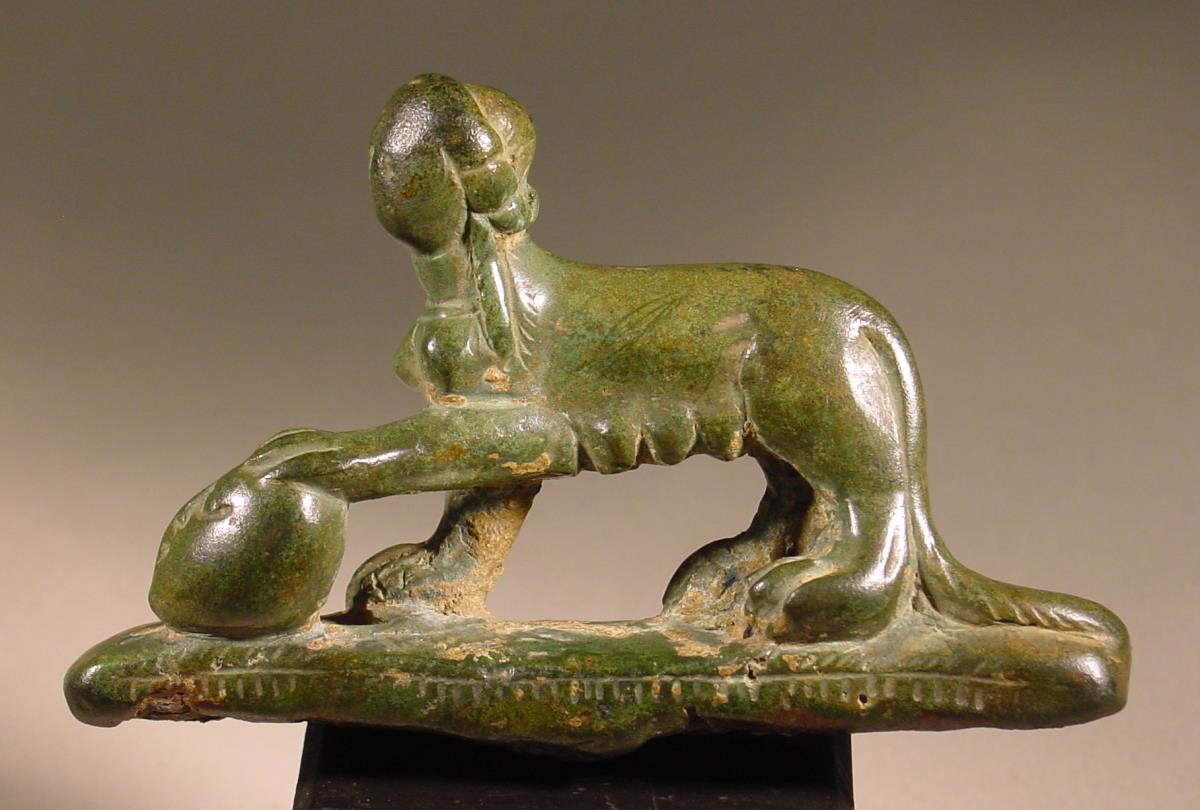 Teil eines Geräts in Gestalt einer Sphinx, die ihre linke Vordertatze auf einen Menschenkopf legt