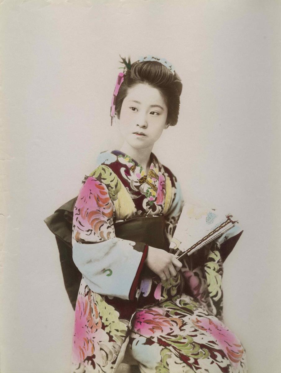 Junge Frau im Kimono mit Faltfächer und Handtasche