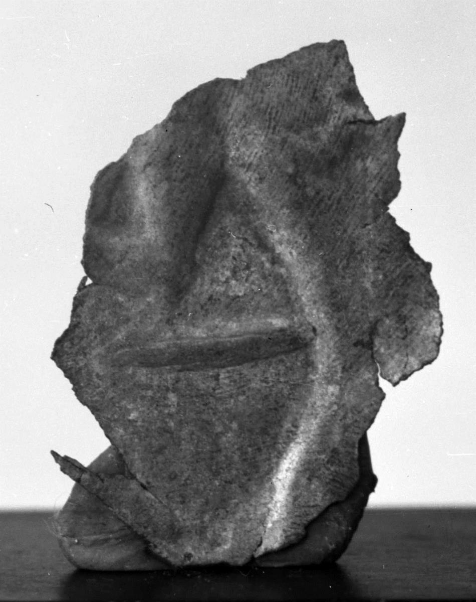 Kleines Blechfragment mit Rest einer figürlichen Darstellung