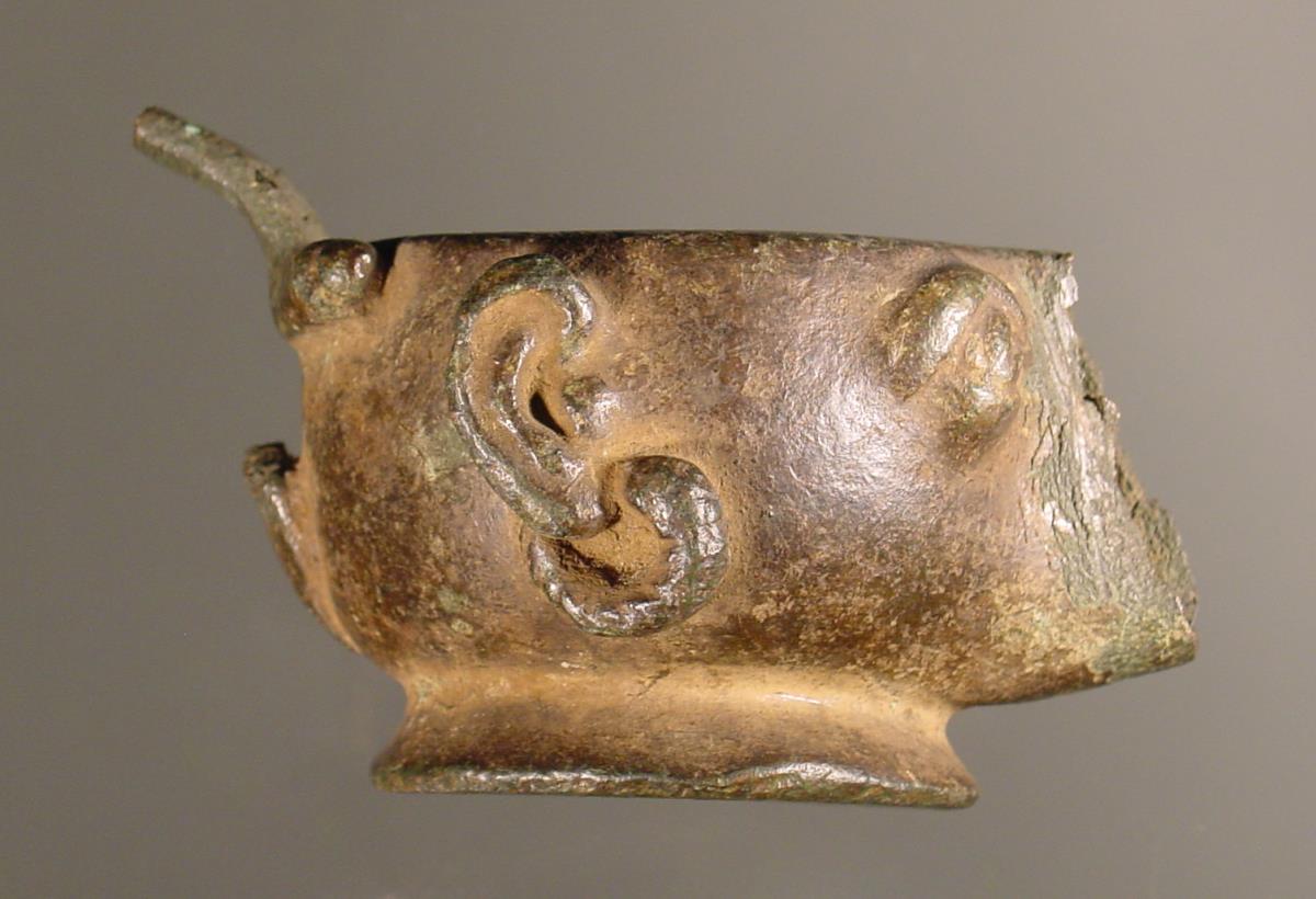 Lampe in Form eines karikierten Menschenkopfes mit Ohrringen und punktierter griechischer Inschrift: ΓΕΛΑΑΝΤΟΧΟΥΓΡΑΜΜΥ (?)