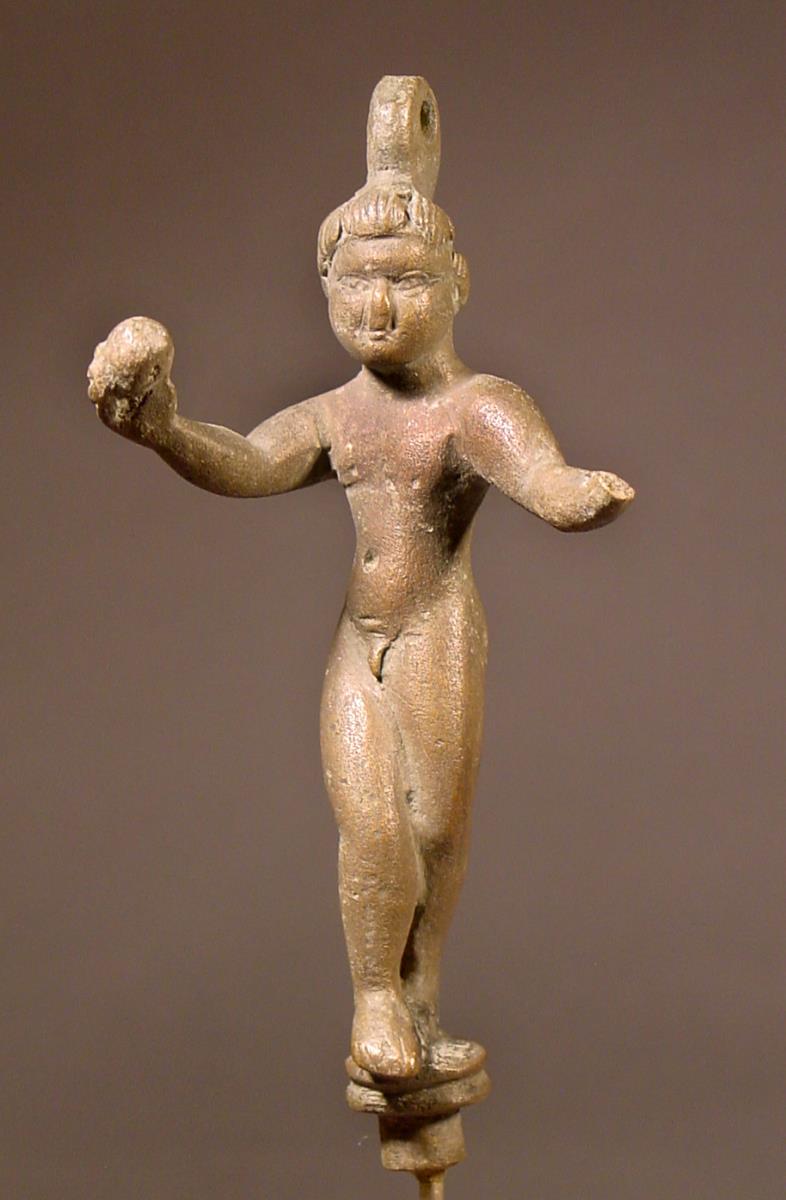 Koptische Gerätfigur eines nackten, tanzenden Knabens mit kleiner Kugel in der Rechten; auf dem Kopf eine Oese