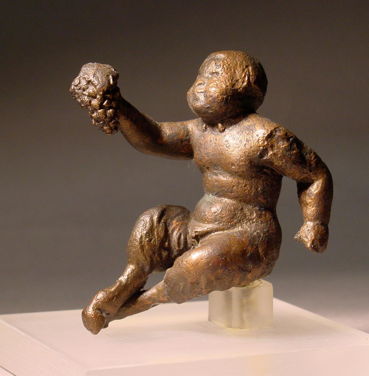Römische Statuette des kindlichen Pan; sitzend, mit Weintraube