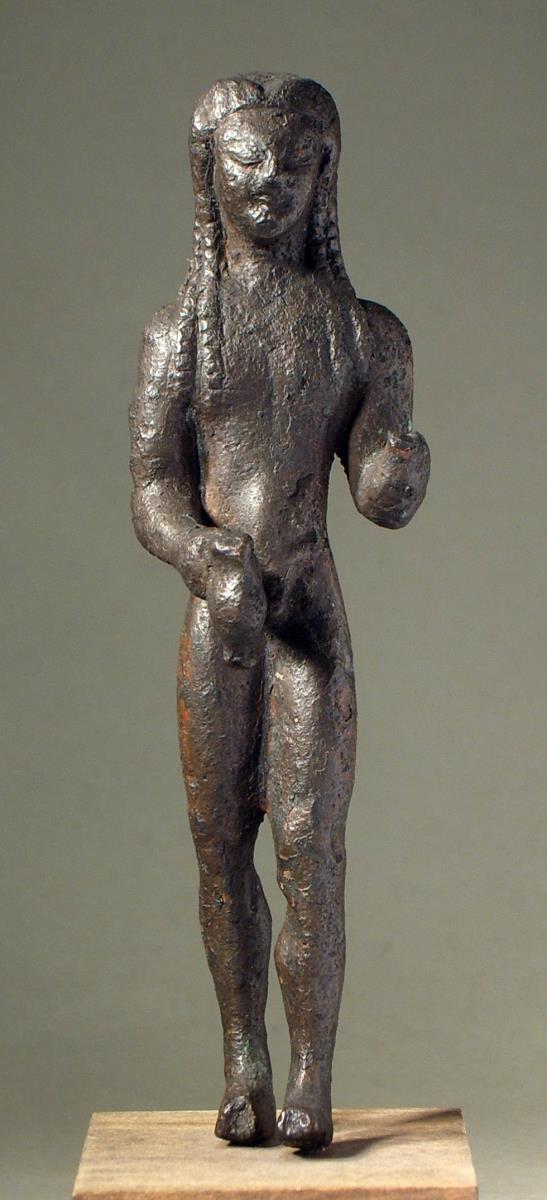 Archaische Statuette eines Kuros mit Spendekanne in der Rechten. Linke Hand und rechte Fußspitze fehlen