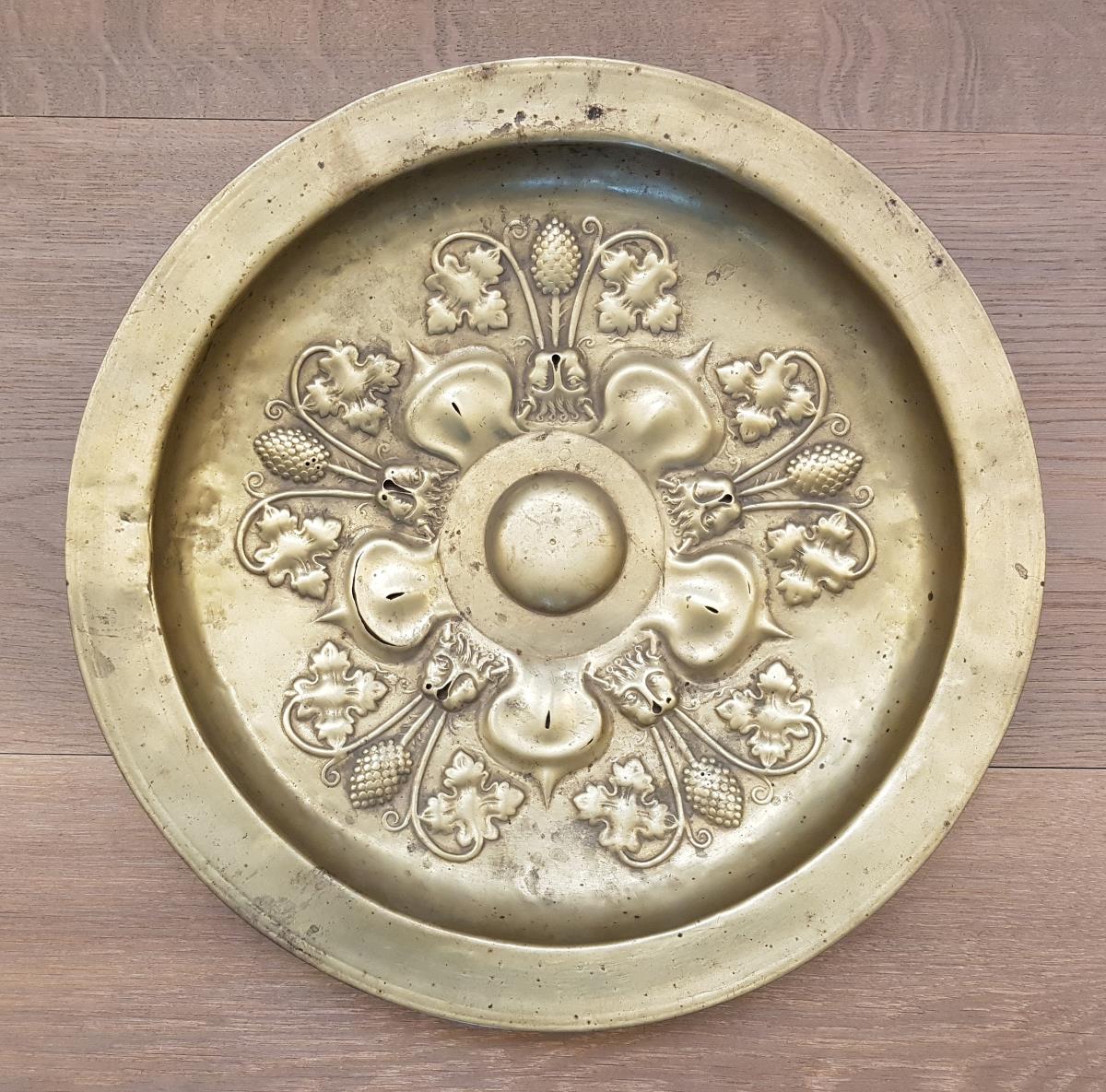Omphalos-Schüssel mit Fünfblatt, Löwenköpfen, Weinblättern und Trauben
