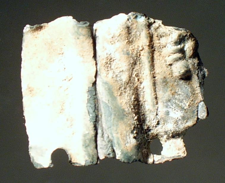 Fragment eines gepressten Blechs, rechts eine Hand