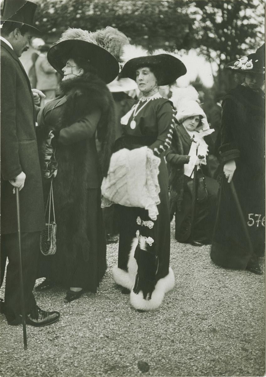 Frauen in Kleidern auf dem Rennplatz