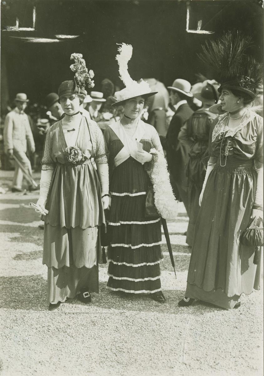 Frauen in Kleidern auf dem Rennplatz
