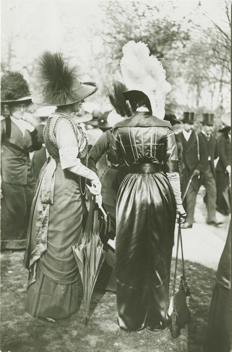 Frauen in Kleidern auf dem Rennplatz