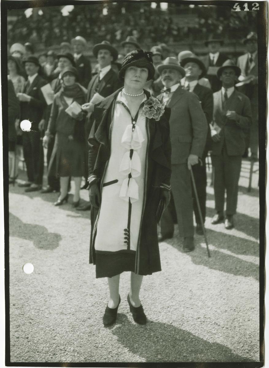 Frau in Kleid und Mantel auf dem Rennplatz in Longchamp