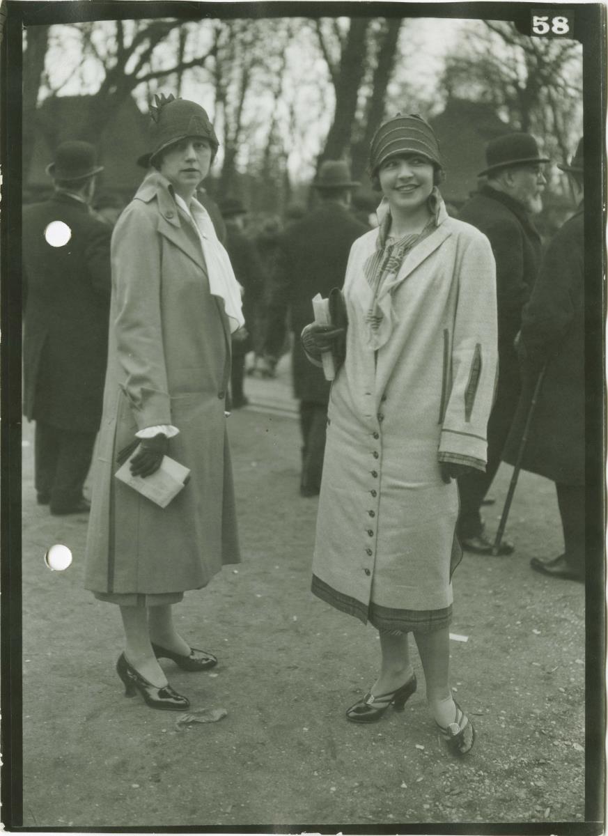 Frauen in Mänteln auf dem Rennplatz