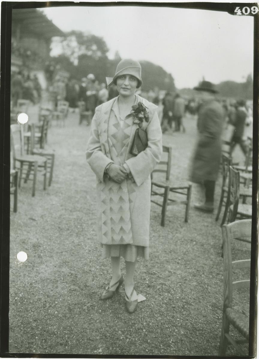 Frau in Mantel auf dem Rennplatz in Longchamp
