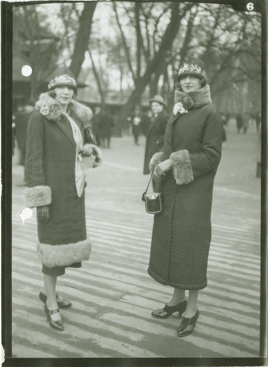 Frauen in Mänteln auf dem Rennplatz