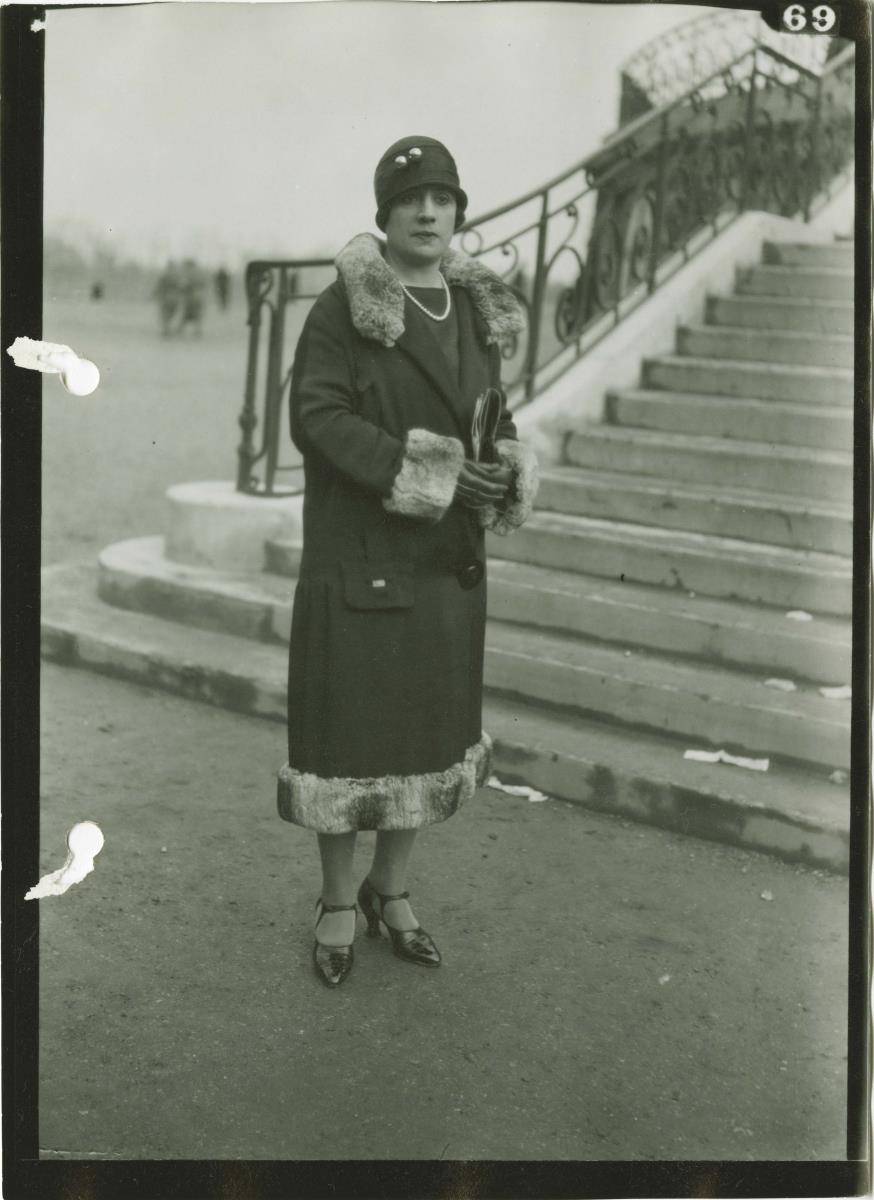 Frau in Mantel auf dem Rennplatz