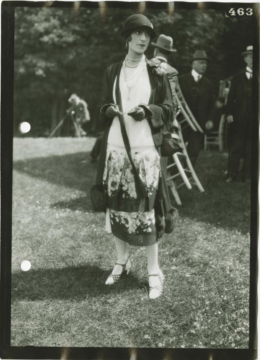 Frau in Kleid und Mantel auf dem Rennplatz in Chantilly