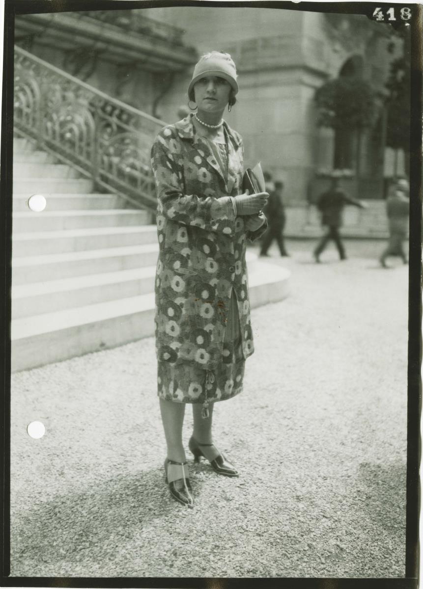 Frau in Kleid und Mantel auf dem Rennplatz in Longchamp
