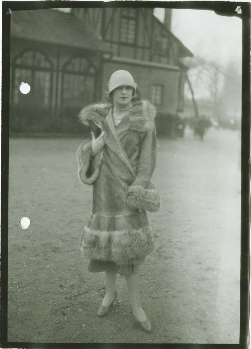Frau in Mantel auf dem Rennplatz
