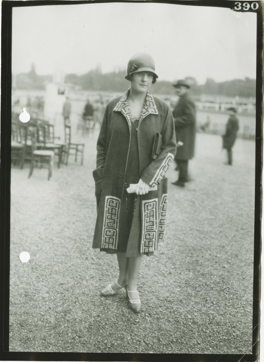 Frau in Kleid und Mantel auf dem Rennplatz in Longchamp