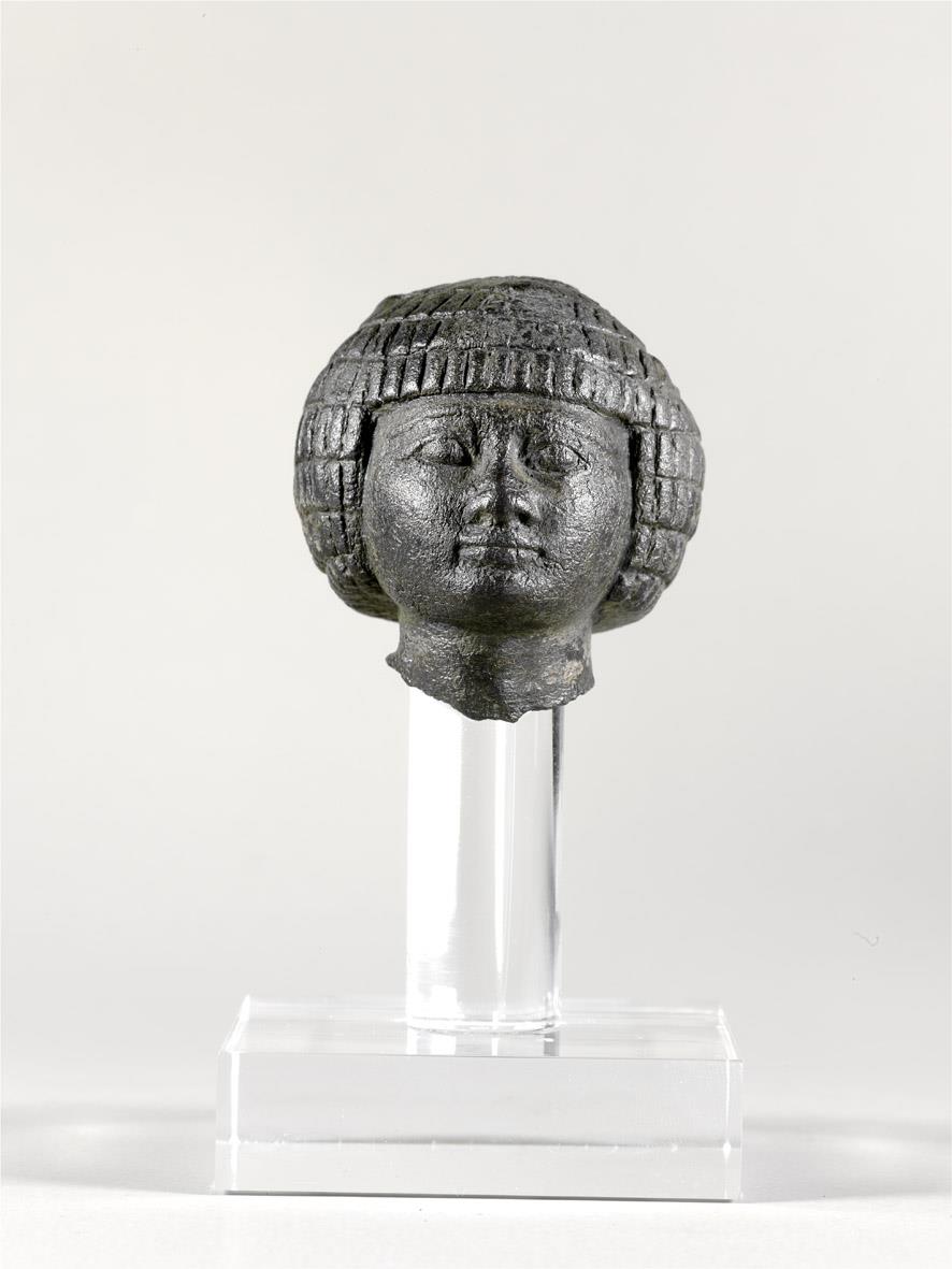 Kopf einer ägyptischen Statuette, reduziert, gut erhalten bis auf ein größeres und ein kleineres Loch im Hinterkopf, schwere graue Kernmasse (Blei?)