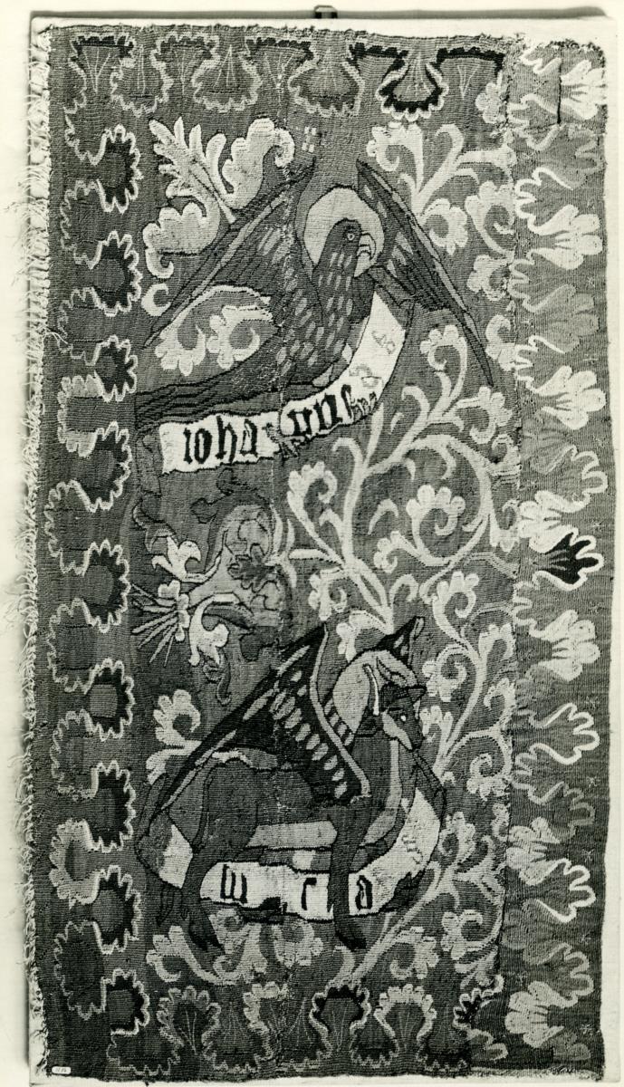 Evangelistensymbole des Johannes und Lukas zwischen Rankenornament
