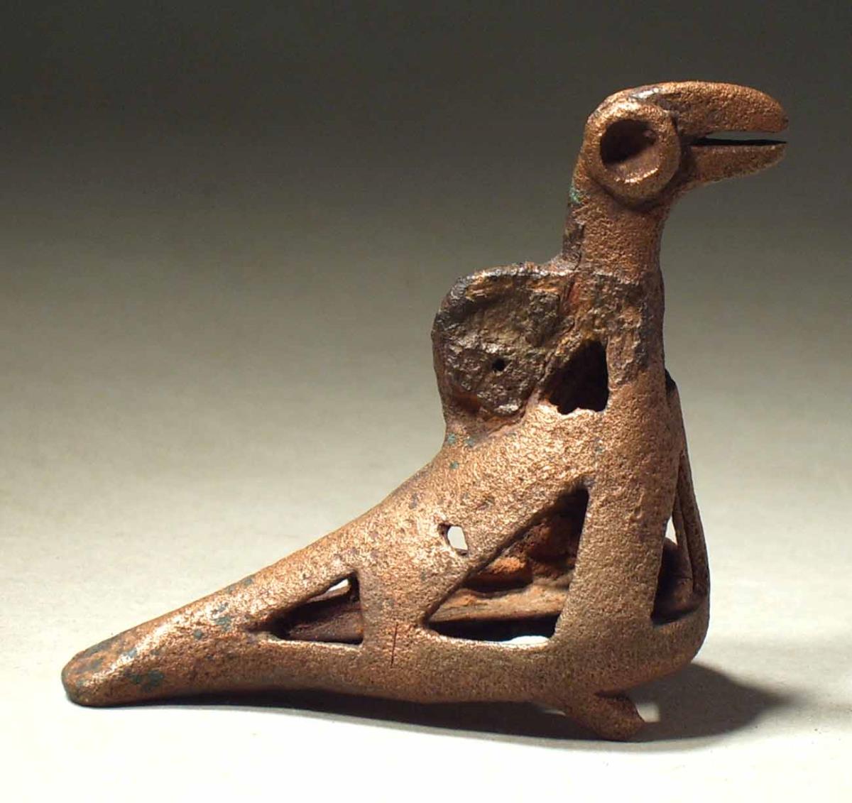 Geometrischer Vogel, Öse am Hals, stark korrodiert, Oberfläche durch Behandlung angegriffen