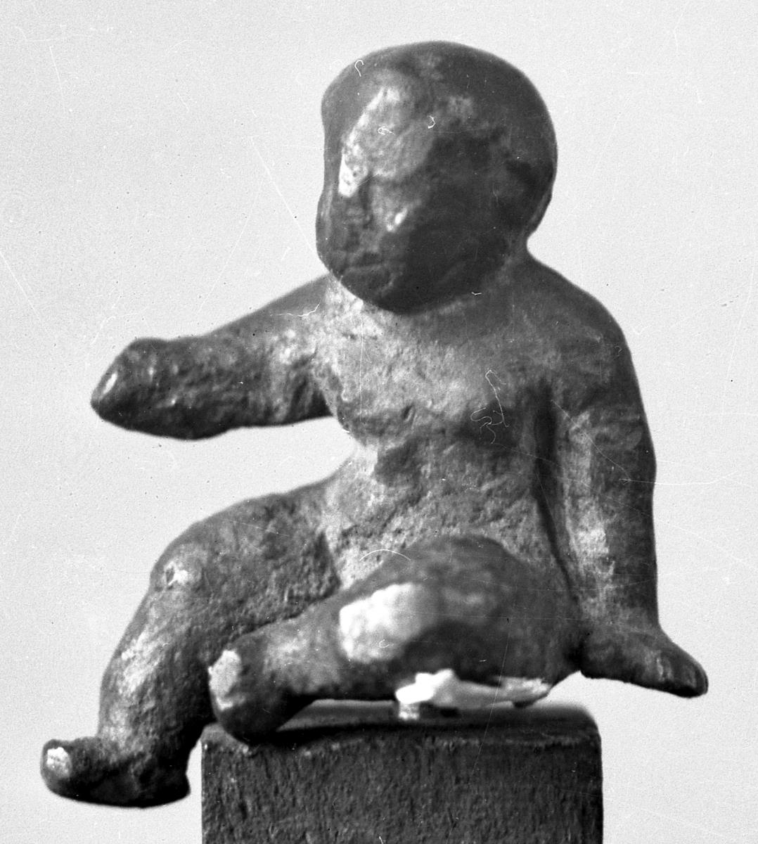 Statuette eines sitzenden nackten Knaben