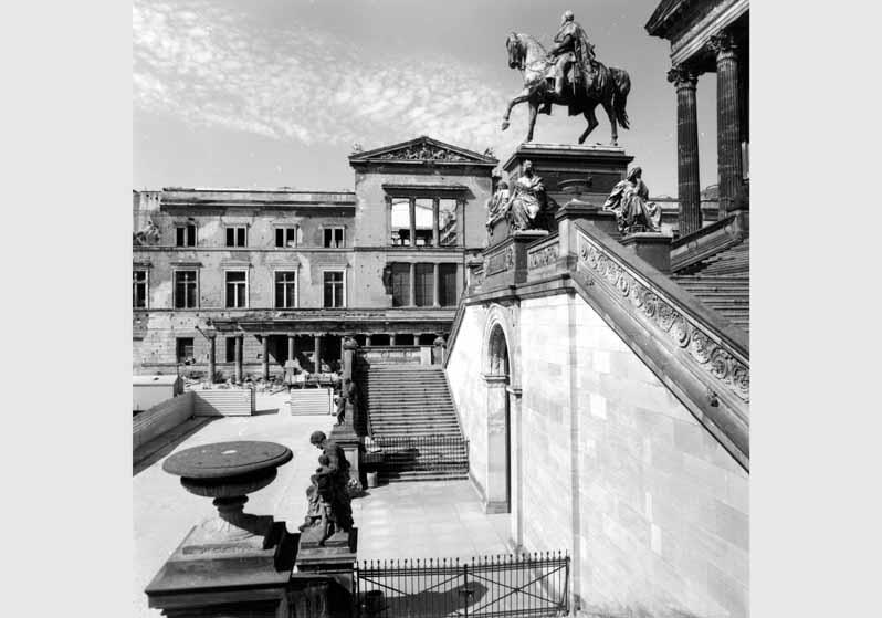 Blick auf die Freitreppe der Nationalgalerie mit dem Reiterstandbild von Alexander Calandrelli vor dem Hintergund des zum Teil zerstörten Neuen Museums