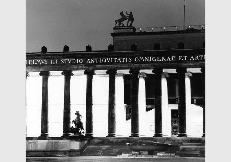 Blick auf die Granitschale von Gottlieb Christian Cantian und die Löwenkämpfergruppe von Albert Wolff vor dem beleuchteten Eingangsbereich des Alten Museums