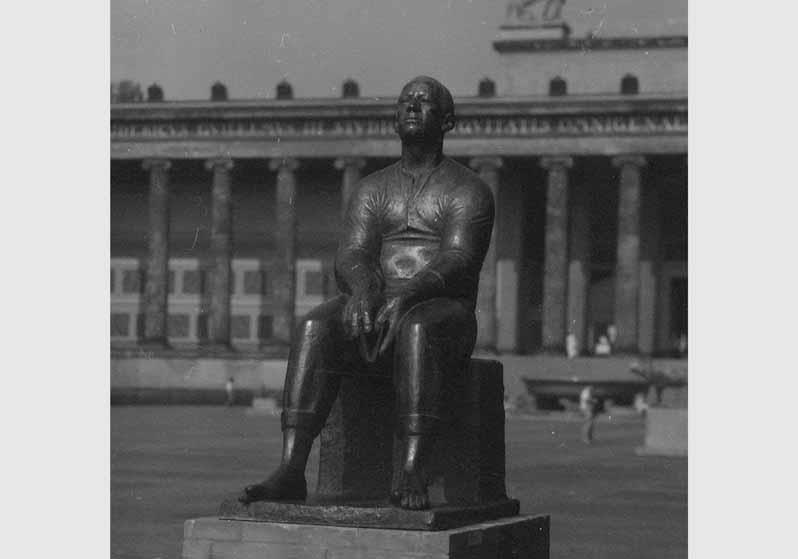 Blick auf die Skulptur "lesender Arbeiter" von Ludwig Engelhardt vor dem Hintergrund des Alten Museums